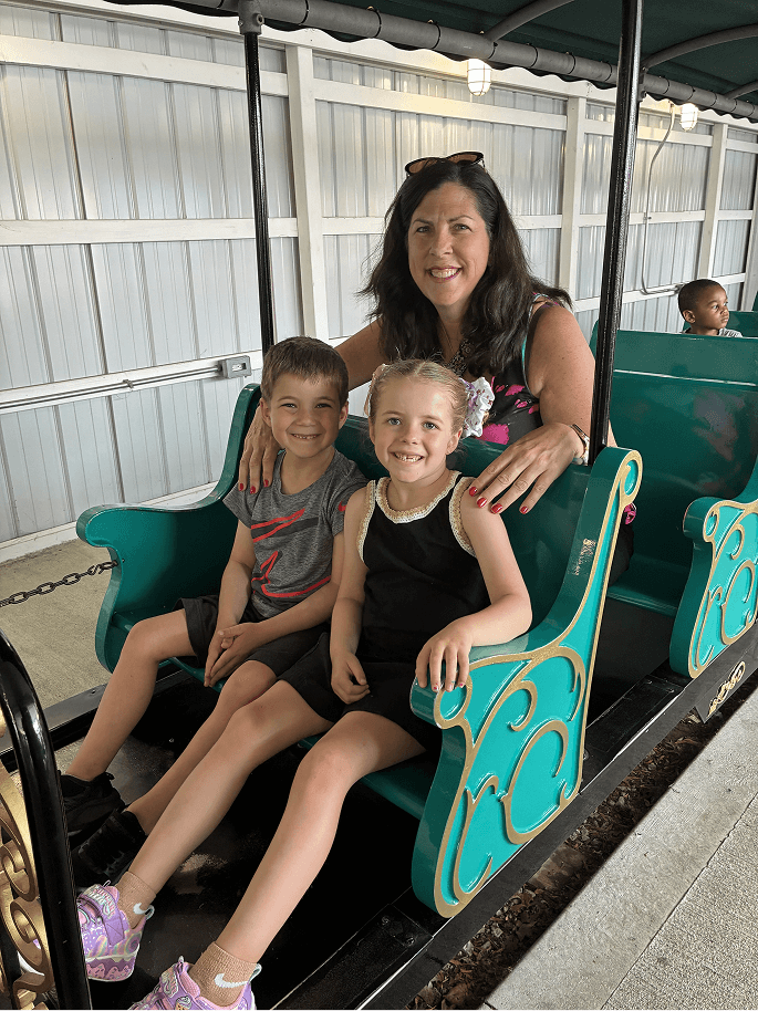 Phyllis with children on amusement park ride